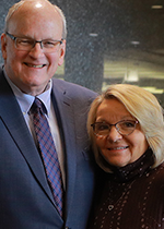 Gary Leidich with his arm around his wife, Marla, as they smile in the foyer of the UToledo Foundation